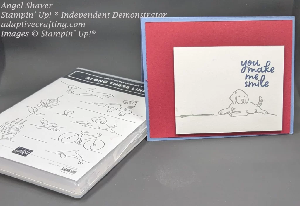 Blue card with front layer of red cardstock.  White rectangle is at the bottom right corner of the front.  It is stamped with a puppy and the sentiment, "you make me smile."
