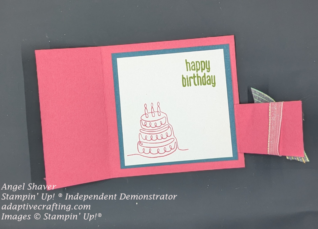 Pink card with blue cardstock framing white rectangle on the interior. The top right of the card is stamped 'happy birthday" and a line art birthday cake is stqamped on the bottom left.