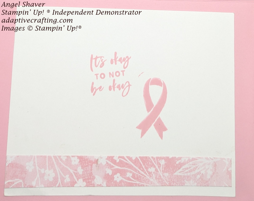 Pink  card with white cardstock inside.  Strip of pink patterned paper with white plants adhered across bottom.   "It's okay to not be okay" and pink support ribbon stamped in the center.