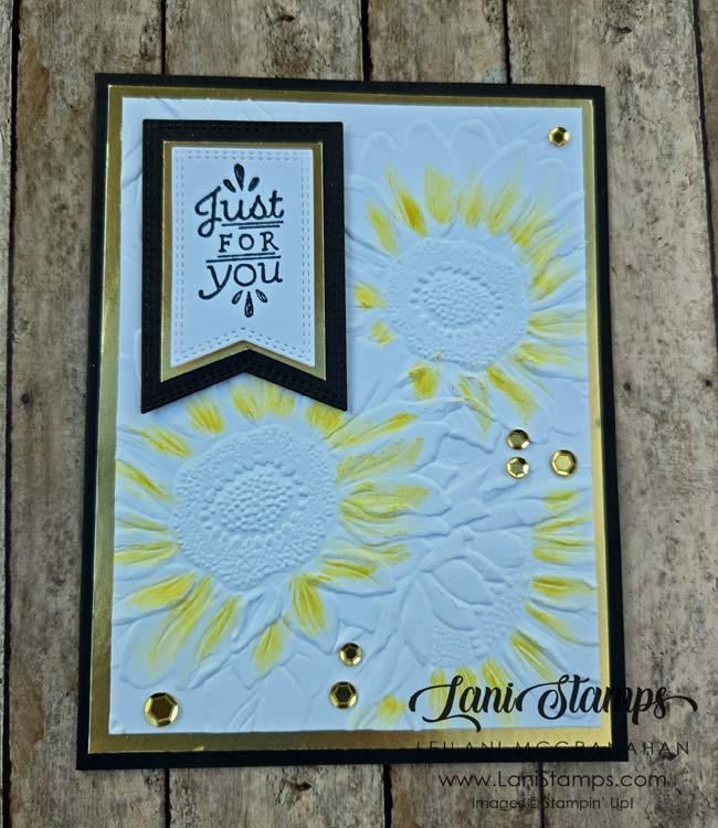 Black card with gold foil layer and white top layer embossd with sunflowers.  Yellow added to sunflower petals.  Sentiment three layer flag says, "Just for you".  Gold sequins finish the card.