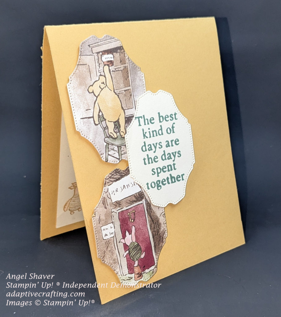 Yellow card with three label shaped dies along left side of card.  The top is an image of Winnie the Pooh standing on a chair reaching to get a pot of honey in the cabinet.  Bottom on is an image of piglet standing on a pot knocking on the door.  Middle die is a sentiment frame that says "The best kind of days are the days spent together."  The card is standing at an angle and you can see piglet colored with the pink shimmer brush