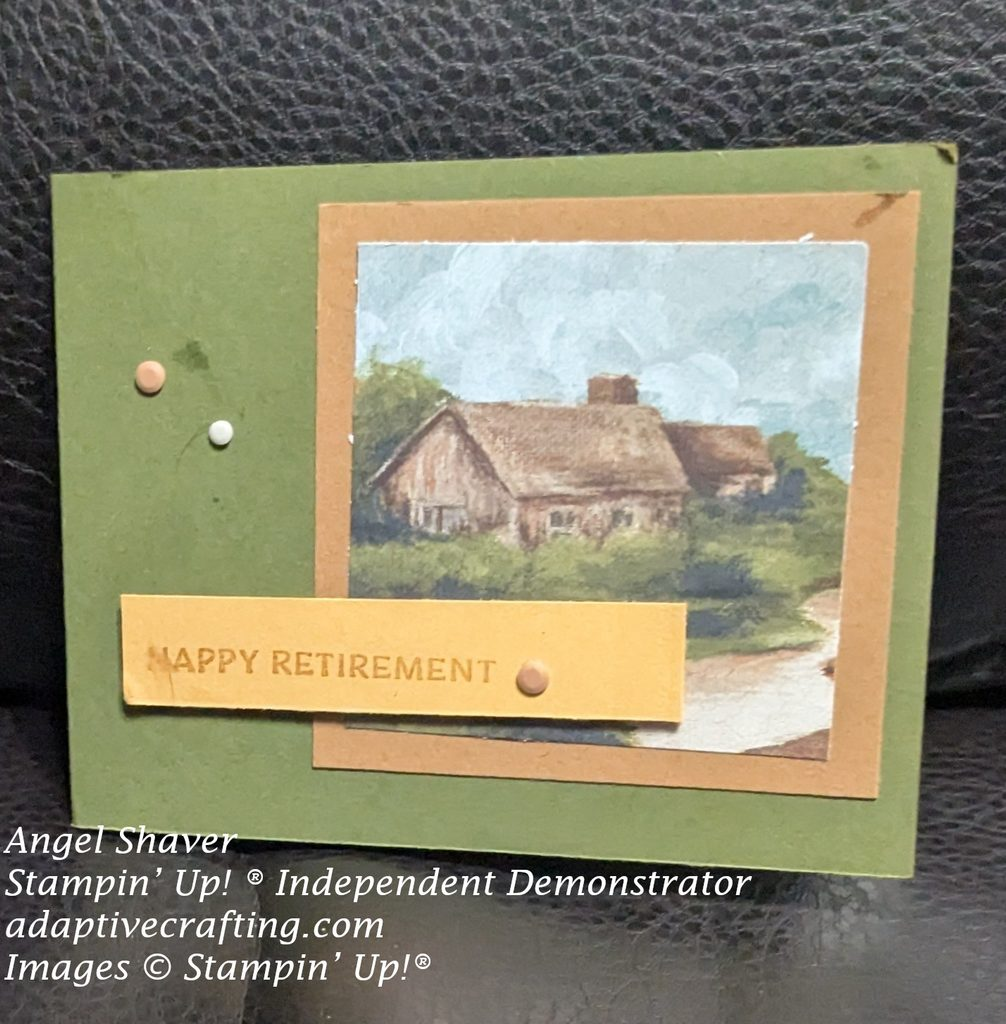 Green card with patterned paper with cabin by a stream image framed in brown.  Gold sentiment strip that says, "Happy Retirement".