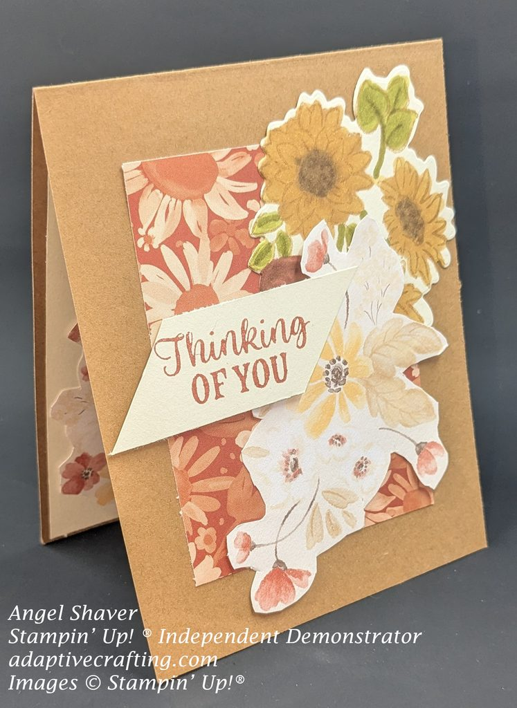 Brown card with panel of rust colored patterned paper with cream or light rust flowers.  Bundles of fall flowers at focal image cascading from top right corner of patterned paper panel.  Stamped and die cut sunflowers. And bundle of flowers cut from Golden Harvest patterned paper.  Sentiment label says, "Thinking of you."