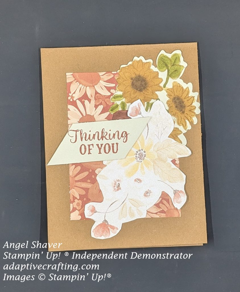 Brown card with rectangle of rust colored monochromatic paper in center of card featuring rust colored sunflowers.  On top of patterned paper rectangle there is a stamped bundle of fall flowers colored with Stampin' Blends alcohol markers.  There is also another bundle of fall flowers fussy cut from patterned paper.  The sentiment label says, "Thinking of you."